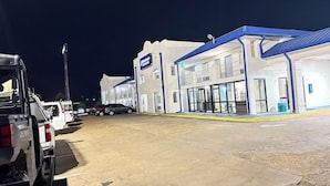 Un estacionamiento con un edificio que tiene techo azul y un letrero que dice 'JOURNAL'.