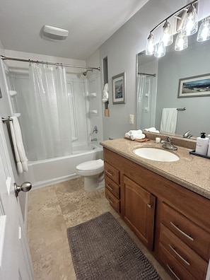 A bathroom with a shower, toilet, sink, and vanity. - Cozy 3BR Escape in Wichita, Patio & Fire Pit (Wichita)
