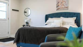 Un dormitorio con una cama, una mesita de noche, un espejo y un cuadro en la pared.