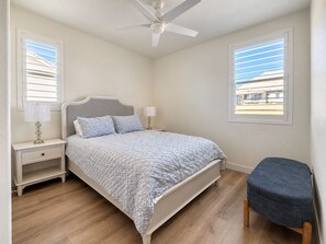 A bedroom with a bed, nightstands, a ceiling fan, and a window. - Spacious 2-bedroom + office/gym townhome in charming Summerlin (Las Vegas)