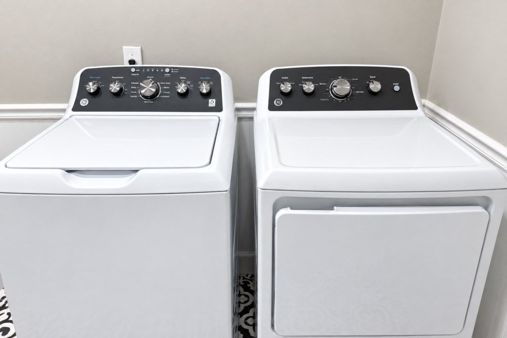 Twee witte wasmachines met voorlaadklep staan naast elkaar in een wasserij.