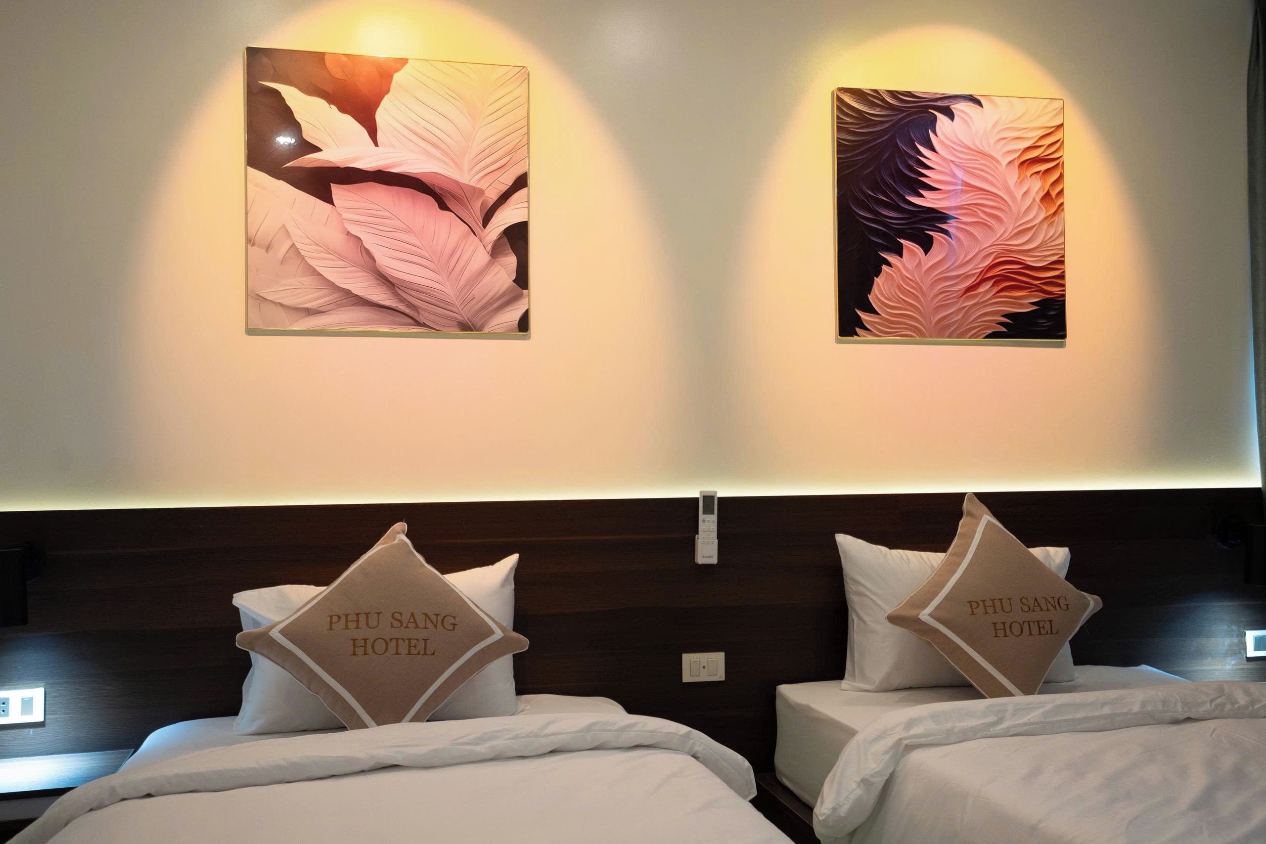 A hotel room with two beds, each with a pillow labeled 'PHU SANG HOTEL'.