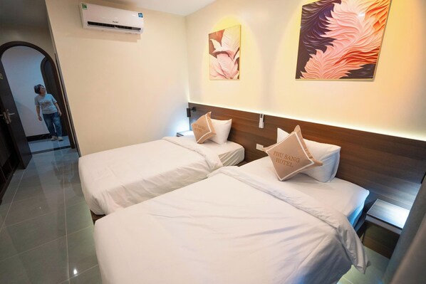 A hotel room with two beds, a wooden headboard, and a wall-mounted air conditioner. - Phu Sang Hotel (Nam Sam Son)