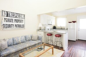 A compact living space with a kitchenette, a sofa, and a coffee table.