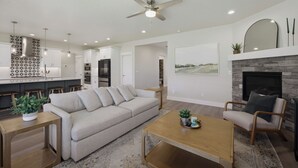A modern living room with a sofa, coffee table, and fireplace. - Spacious High End Ranch near Lake Lowell (Nampa)