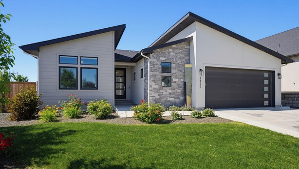 A two-story house with a garage, a front porch, and a well-maintained lawn. - Spacious High End Ranch near Lake Lowell (Nampa)