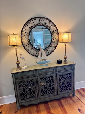 A wooden console with a decorative mirror above it, flanked by two lamps and a small sailboat model. - Historic charm meets contemporary style-steps away from downtown and waterfront (Washington)