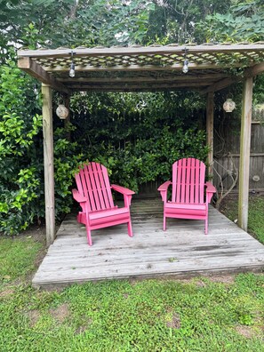 A wooden deck with two Adirondack chairs under a pergola with hanging lights. - Historic charm meets contemporary style-steps away from downtown and waterfront (Washington)