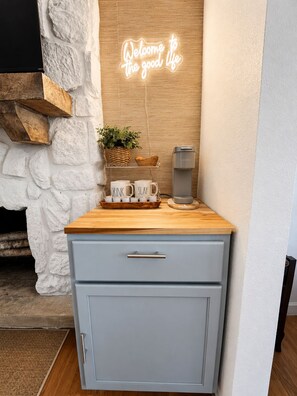 A kitchenette with a neon sign, a coffee maker, and a tray with mugs. - Lakefront Getaway With Dock Near Bagnell Dam & Dining (Sunrise Beach)