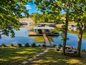 A lakeside dock with a covered seating area, a fire pit, and boats. - Lakefront Getaway With Dock Near Bagnell Dam & Dining (Sunrise Beach)