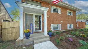 A two-story brick house with a front porch, a welcome sign, and a flag. - 4-bedroom house in delightful North Chicago with AC (North Chicago)