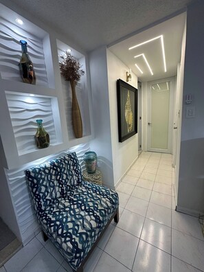 Ein modernes Interieur mit einer Couch, dekorativen Vasen und einem gerahmten Kunstwerk an der Wand.
