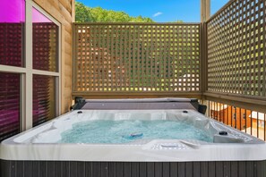 Ein Whirlpool mit Holzterrasse und einem Spalierzaun.