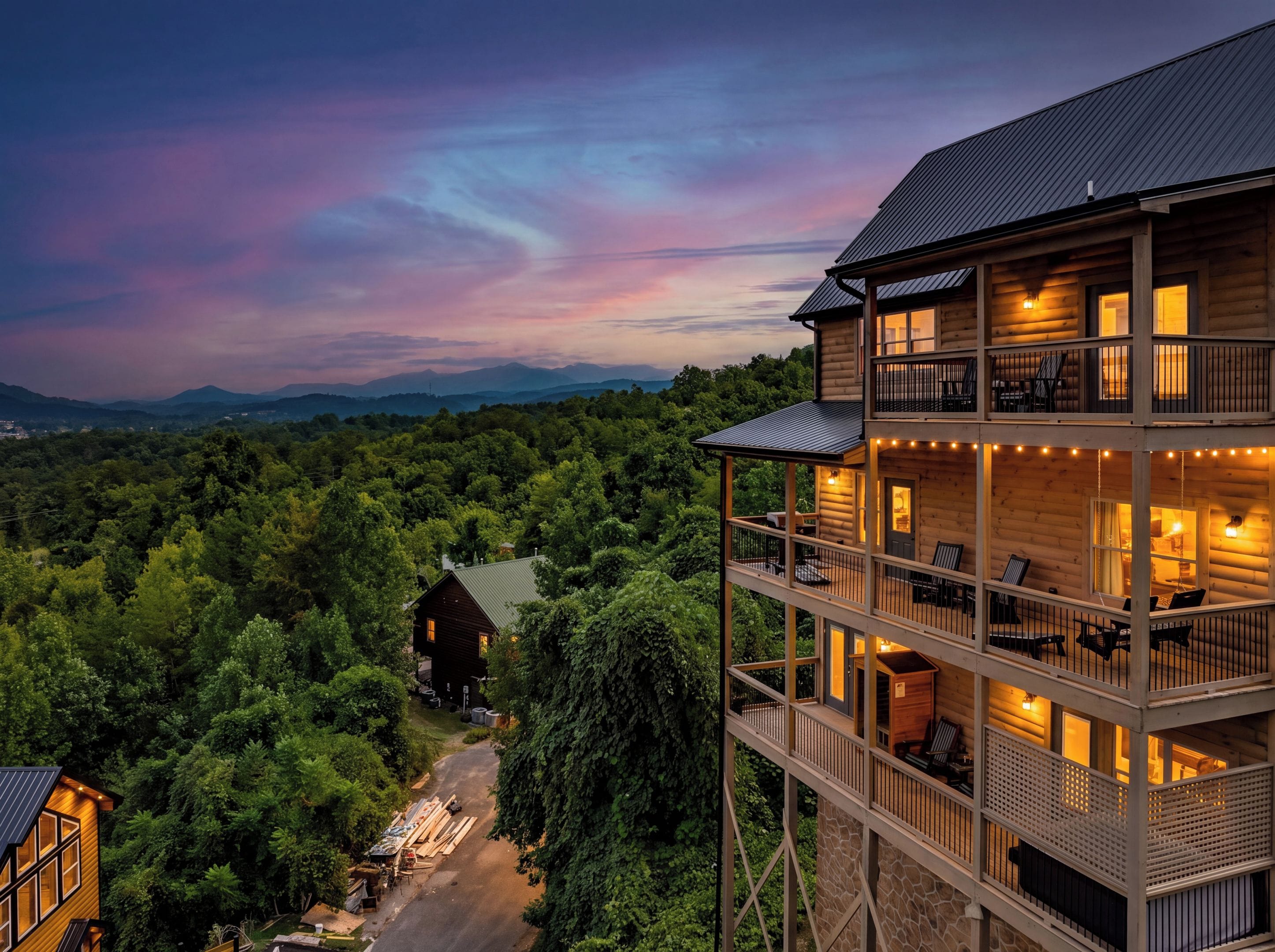 A multi-story wooden cabin with balconies, surrounded by dense forest, and a view of distant mountains.