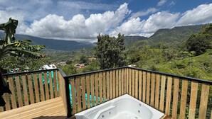 A wooden deck with a hot tub and a view of a mountainous landscape. - Alegria Stay Glamping in Cocorná (Cocorná)