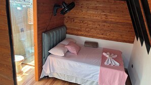 A bedroom with a wooden ceiling, a bed with pink bedding, a headboard, and a towel on the bed. - Alegria Stay Glamping in Cocorná (Cocorná)