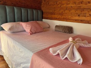 Ein Bett mit Kopfteil, Kissen und einem Handtuch.