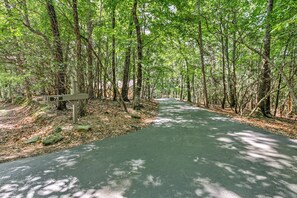 Ein gepflasterter Weg durch ein bewaldetes Gebiet mit einem Wegweiser, der die Nummer 75 anzeigt.