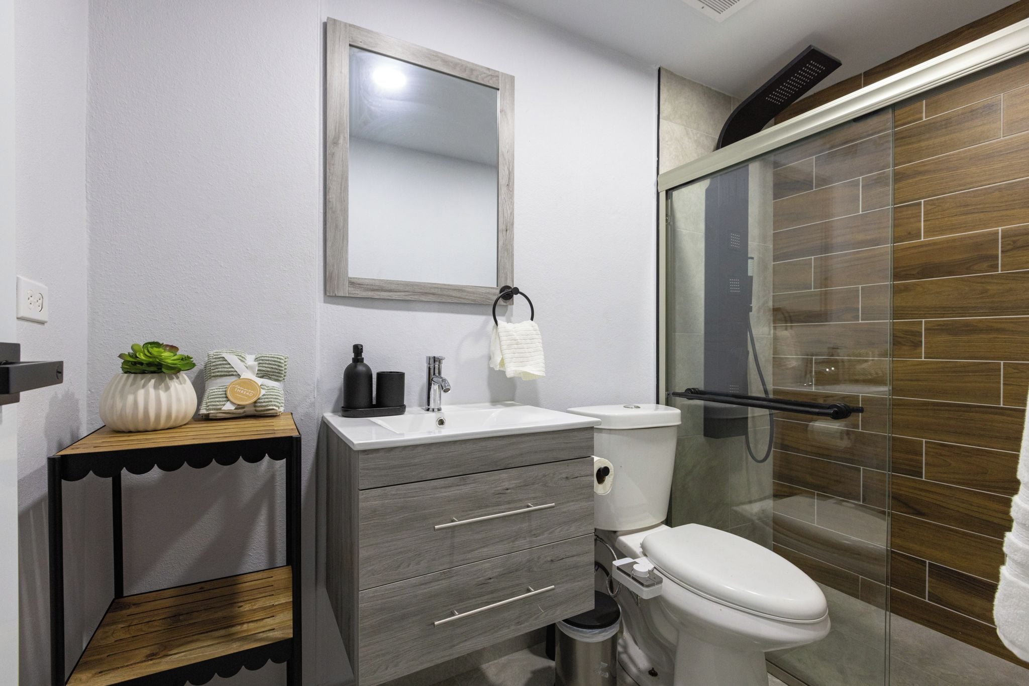 A modern bathroom with a toilet, sink, and shower area.