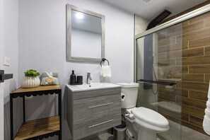 A modern bathroom with a toilet, sink, and shower area.