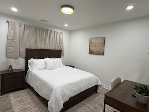 A bedroom with a bed, nightstand, bedside table, and a desk with a chair. - Modern 3BR near UT Stadium, Domain & Downtown Austin (Austin)