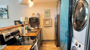 Cocina compacta con cafetera, microondas y lavadora.