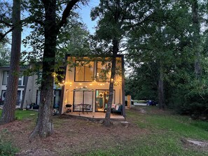 A modern house with a patio, surrounded by trees. - Charming Waterwood Getaway 2BR/2BA Golf Retreat Near Lake Livingston (Huntsville)