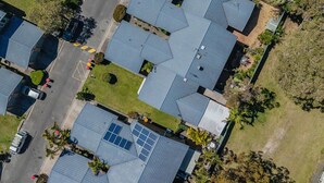 Ein Wohngebiet mit mehreren Häusern, jedes mit geneigtem Dach und Solaranlage.