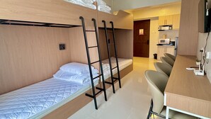A compact hotel room with bunk beds, a kitchenette, a dining area, and a bathroom. - Royal Oceancrest Panglao 1 (Dauis)