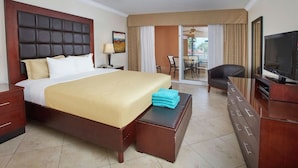 A hotel room with a large bed, a television, a desk, and a ceiling fan. - 2-bedroom Penthouse Condo in Divi Golf & Beach with breathtaking Oceanfront view (Oranjestad)