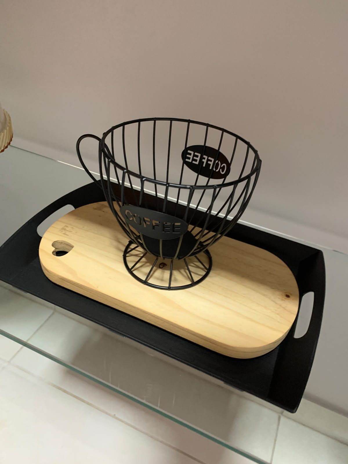 A black metal coffee basket with the word 'COFFEE' on a wooden tray.
