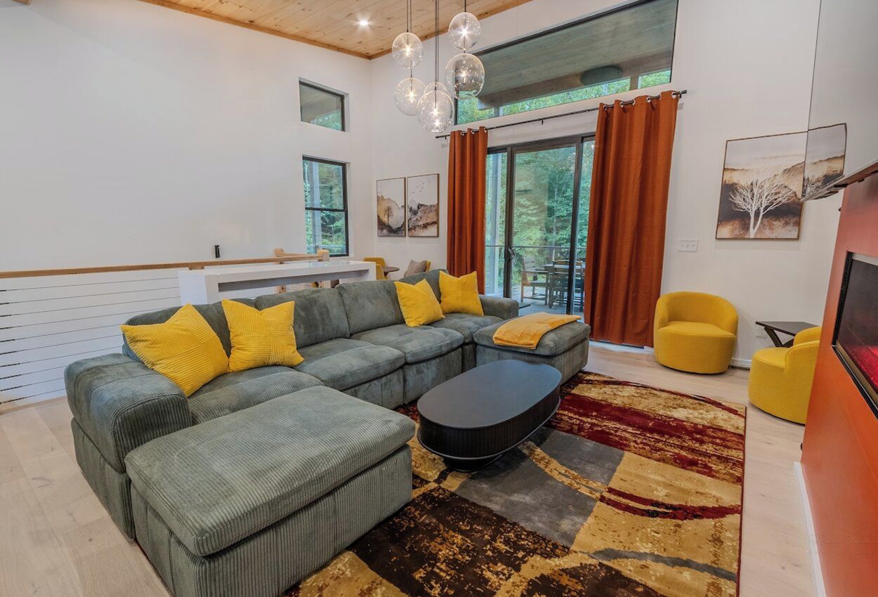 A modern living room with a sectional sofa, a coffee table, and a view of the outdoors.