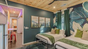 A bedroom with two beds, a ceiling fan, and a large botanical mural on the wall.
