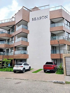Ein mehrstöckiges Gebäude mit einem auffälligen Schild, auf dem 'SEASON SMART FLATS' steht.