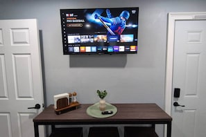 A flat-screen TV mounted on a wall displaying a sports channel interface.