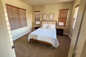 A bedroom with a large bed, two bedside tables, a headboard, and three wall-mounted picture frames. - Colorado Springs Family Retreat 4BR, Game Loft & Garage (Colorado Springs)