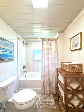 Ein Badezimmer mit Toilette, Badewanne und Duschvorhang.