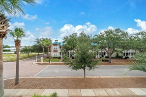 A residential area with a two-story house featuring a blue roof, a driveway, and a sidewalk. - Village at Blue Mtn Beach 625 - Close to beach located in 30A (Santa Rosa Beach)