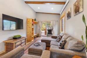 A cozy living room with a flat-screen TV, wooden furniture, and a view of the outside. - Family Cabin in Breckenridge Tiger Run Resort 5 min to Gondola (Breckenridge)