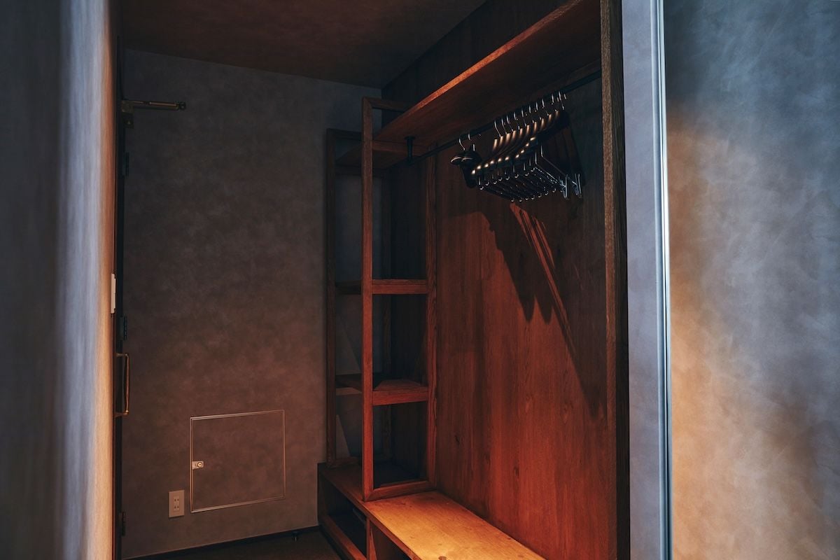 Um closet amplo com prateleiras de madeira e cabideiro.
