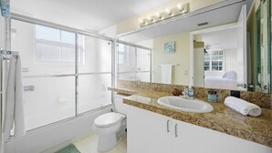 A bathroom with a shower, toilet, sink, and a large mirror. - Charming 3 Bedroom Apartment in Aventura - Cozy and Beautifull, Ideal for Family (Aventura)