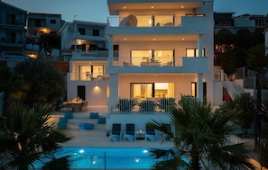 A multi-story residential building with a pool, balconies, and outdoor seating. - Cozy home in Okrug Gornji with private swimming pool, can be inside or outside (Okrug Gornji)