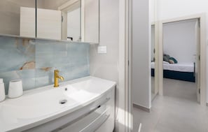 A modern bathroom with a white vanity, a gold faucet, and a marble backsplash. - Cozy home in Okrug Gornji with private swimming pool, can be inside or outside (Okrug Gornji)