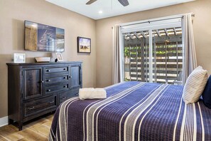 A bedroom with a bed, a dresser, a television, and a window with a view. - The Regency Royale | Oceanfront | Private Pool (Virginia Beach)