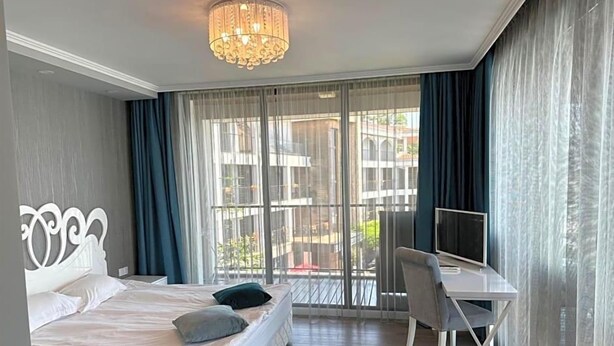 A hotel room with a bed, a desk, and a television. - Regina Maria (Balchik)