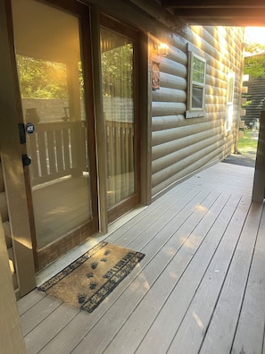 A wooden cabin with a sliding glass door, a wooden deck, and a doormat. - Zen Bear’s Den our Beautiful cozy cabin 2 miles to Dollywood in Pigeon Forge TN. (Pigeon Forge)