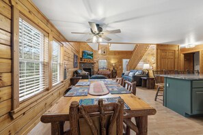 A wooden cabin interior with a dining area, kitchen, and living space. - Zen Bear’s Den our Beautiful cozy cabin 2 miles to Dollywood in Pigeon Forge TN. (Pigeon Forge)