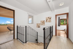 A staircase with black railings leading to a balcony with a chair. - Villa Nina u Poreču, Istra by Istrabook (Poreč)