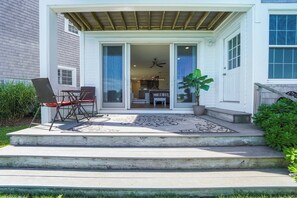 A covered patio with a dining area, a ceiling fan, and a potted plant.