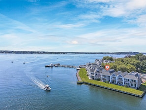 Ein Anwesen am Wasser mit einer Anlegestelle, Booten und einem mehrstöckigen Haus.